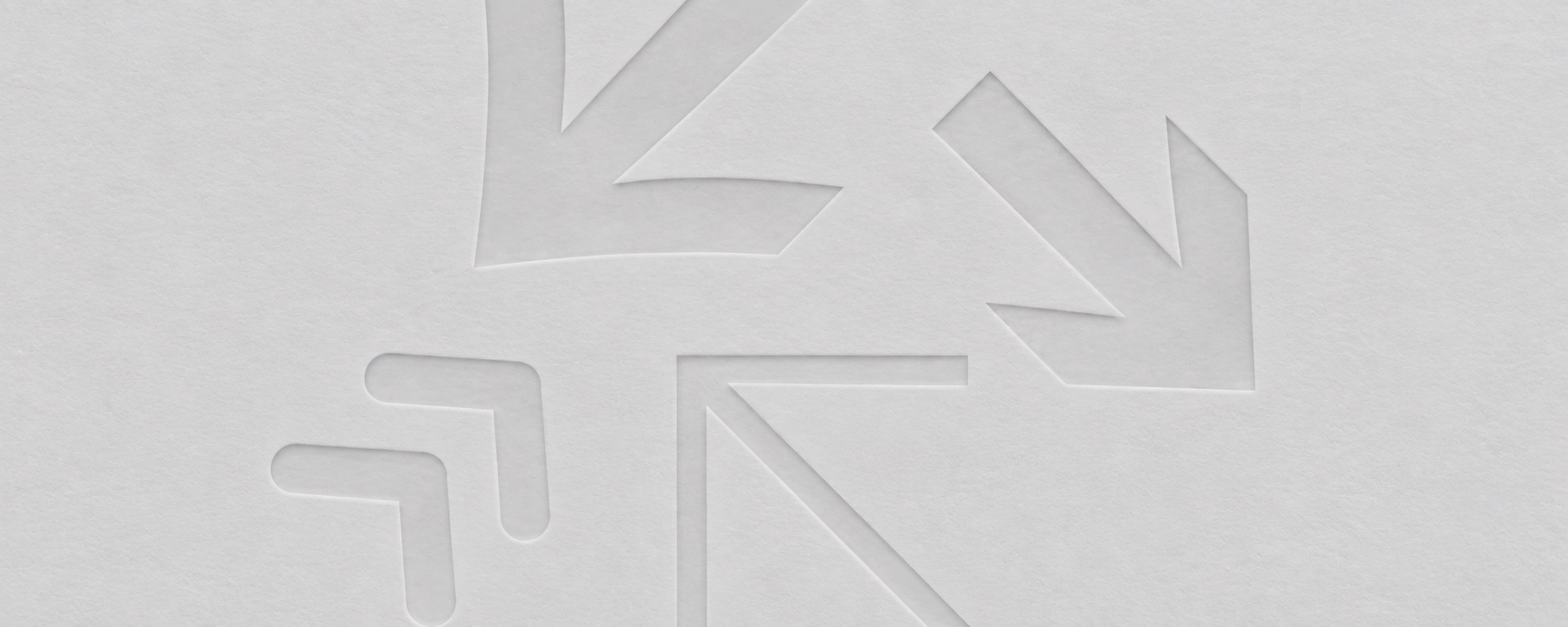 Directional signage arrows pointing outward from a junction, blind-embossed on paper.